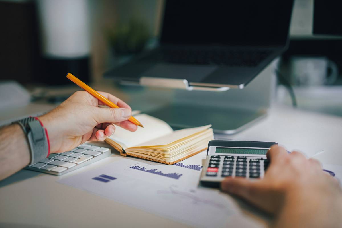 A person reviewing tax documents with a highlighter, applying a tax reduction tactic to lower their bill
